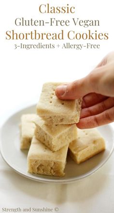 a hand is picking up some shortbread cookies on a plate with the title in the middle