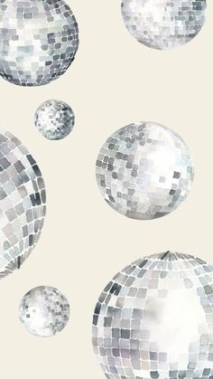 several shiny disco balls floating in the air with white and grey colors behind them on a beige background