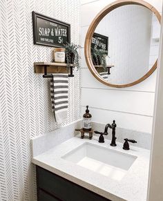 a bathroom sink under a round mirror in front of a wall mounted faucet