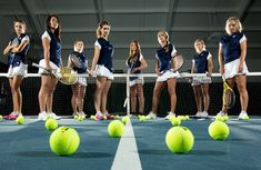 a group of people standing on top of a tennis court holding racquets