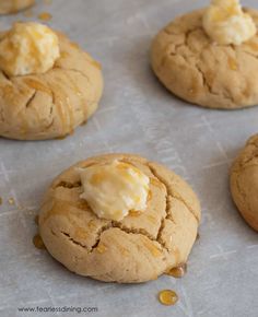 several cookies with butter on them sitting on a baking sheet