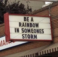 a sign that says be a rainbow in someone's storm on the side of a building