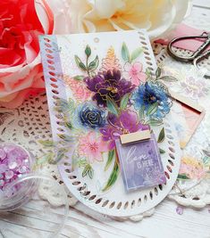 a card with flowers on it sitting next to some scissors and other crafting supplies