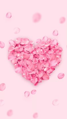 a heart made out of pink petals on a pink background