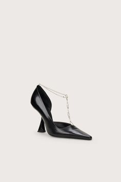 A smooth leather pump with architectural comma-heel and silver-toned removable chainlink toe strap. — Pointed toe — Comma heel — Rubber sole — Smooth leather — 4" heel height Swimming Bag, Cult Gaia, Kids Sandals, Accessories Jewelry Earrings, Rubber Heels, Black Pumps, Leather Pumps, Leather Jewelry, Lifestyle Brand