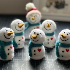 small snowmen with hats and scarves sitting on a table