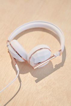 a pair of white headphones sitting on top of a wooden table next to ear buds