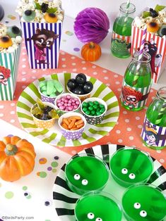 the table is set up for halloween party with candy, candies and cupcakes