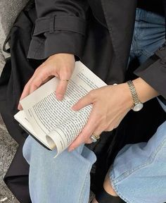 a person sitting on the ground reading a book