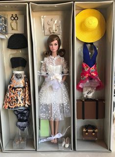 two barbie dolls are dressed in white dresses and hats