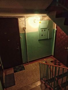 an overhead view of a stairwell leading to two doors and a light on the wall