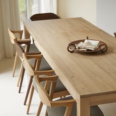 a wooden table with chairs around it and a plate on the table next to it