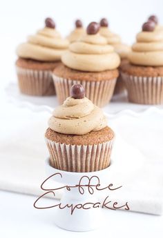 cupcakes with frosting and chocolate chips on top are sitting on a white plate