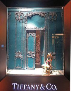 a display case with an ornate door and chair in front of the entrance to tiffany & co