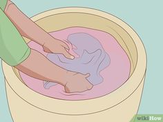 a person washing their feet in a bucket filled with pink colored water and foamy liquid