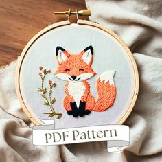 an embroidered fox is sitting next to a branch with flowers on it and the words pdf pattern above it