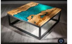 a coffee table made out of wood with blue paint on the top and black metal legs