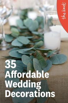 an image of a table setting with candles and greenery on the table for a wedding reception