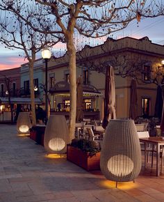 outdoor seating area with tables and umbrellas at dusk