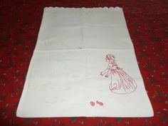 a white table cloth with a red drawing of a woman in a dress on it