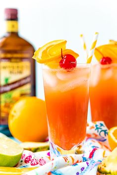 two glasses filled with orange juice and garnished with cherries