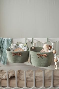 two baskets are sitting on top of a crib