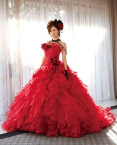 a woman in a red dress standing by a window