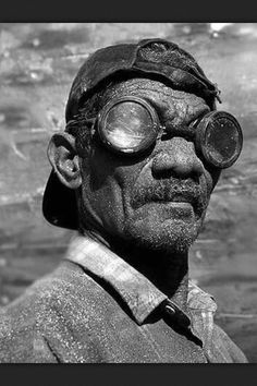 an old man wearing goggles and a hat