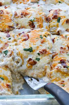 a cheesy casserole dish is shown with a spatula