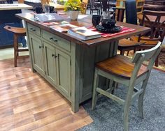 a kitchen island with two chairs and a table in the middle, surrounded by other furniture