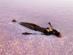 a woman laying on the ground in some water