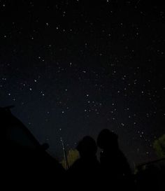 two people looking up at the stars in the night sky