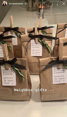 small brown bags with black ribbons tied to them and some tags on the handles that read, neighbor gifts