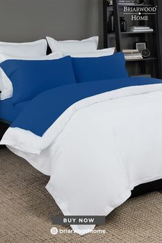 blue and white bedding in a bedroom with carpeted flooring on the side