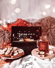 a laptop computer sitting on top of a table next to cookies and other food items