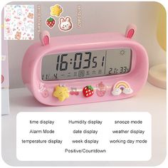 a pink alarm clock sitting on top of a table