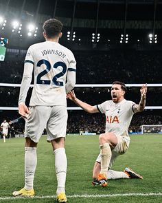 two soccer players are congratulating each other on the field