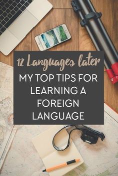 a desk with a laptop, camera and other items on it that says language later my top tips for learning a foreign language