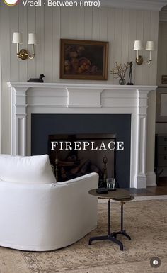 a living room with a fire place next to a white couch and table in front of a fireplace