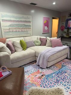 a living room filled with lots of furniture next to a painting on the wall and rug