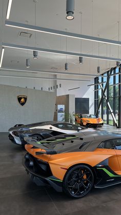 an orange and black sports car in a showroom