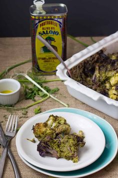 a plate with broccoli on it next to a container of mustard and a fork