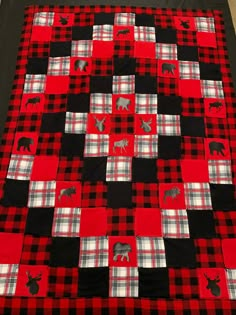 a red and black quilt with animals on it