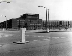 an old black and white photo of a street corner with a building in the background