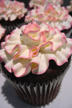 an image of cupcakes with pink and white frosting on them for sale