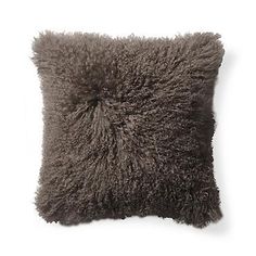 a gray pillow with fluffy fur on the front and back of it's sides