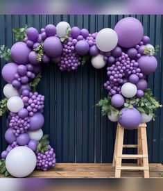 a purple and white balloon arch with grapes