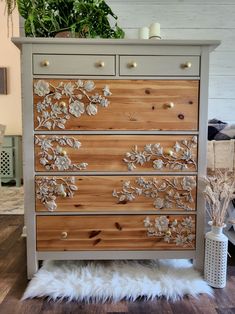 a dresser with flowers painted on the drawers and white fur rug in front of it