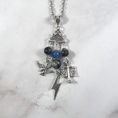 a necklace with various charms and symbols hanging from it's sides on a marble surface