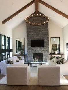 a living room with two couches and a fire place in the middle of it